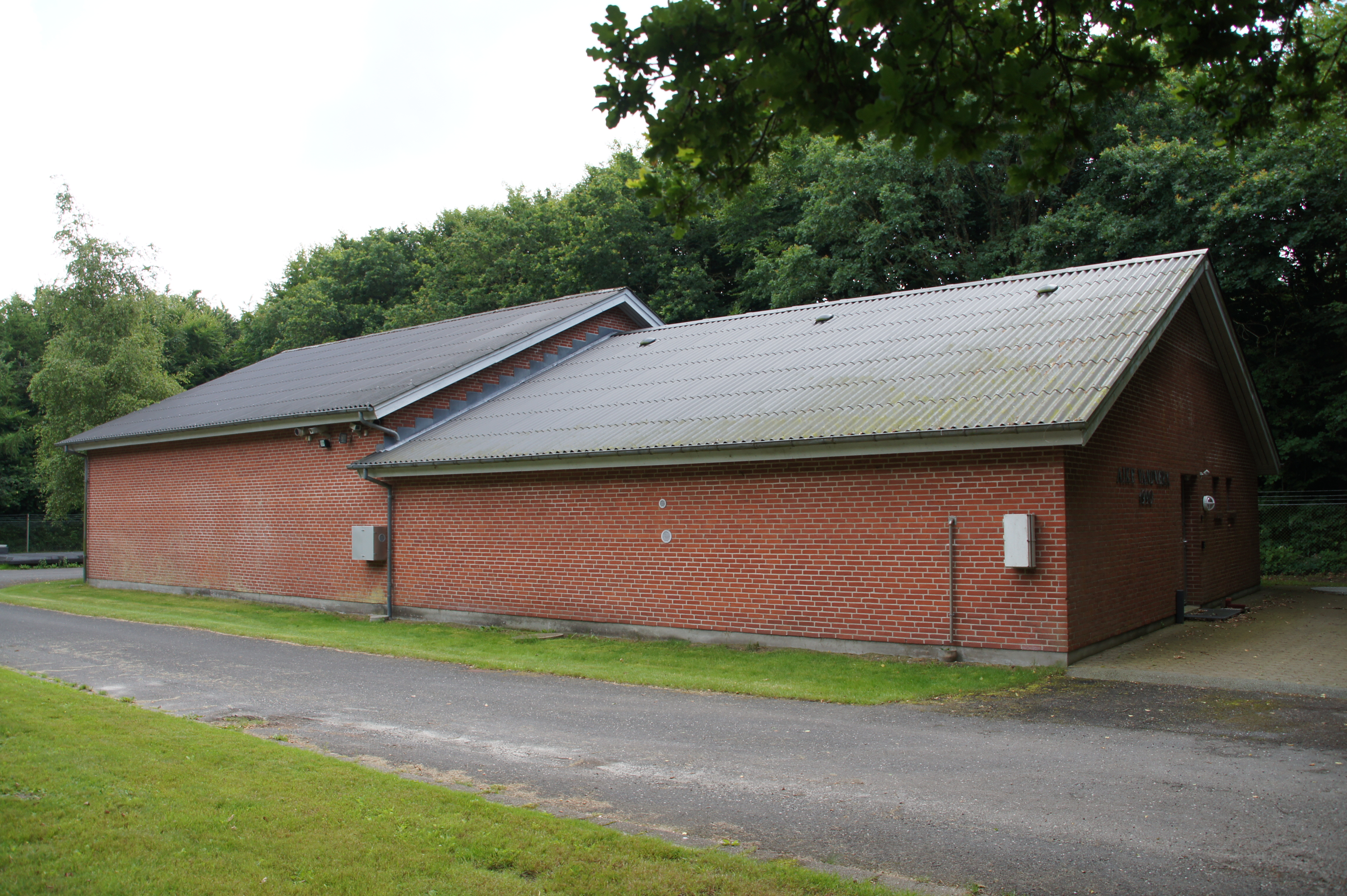 Aike Vandværk, Rød bygning med sort tag ved en grusvej